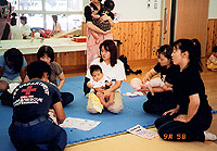 人形を使っての説明を受ける親子ずれの写真