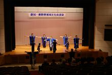 長めの紫の法被を着た演者の方がステージの上と下で踊る様子を観客席から写した写真