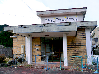 ベージュを基調とし、手前に小さな柵が設置してある三沢小学校玄関の写真