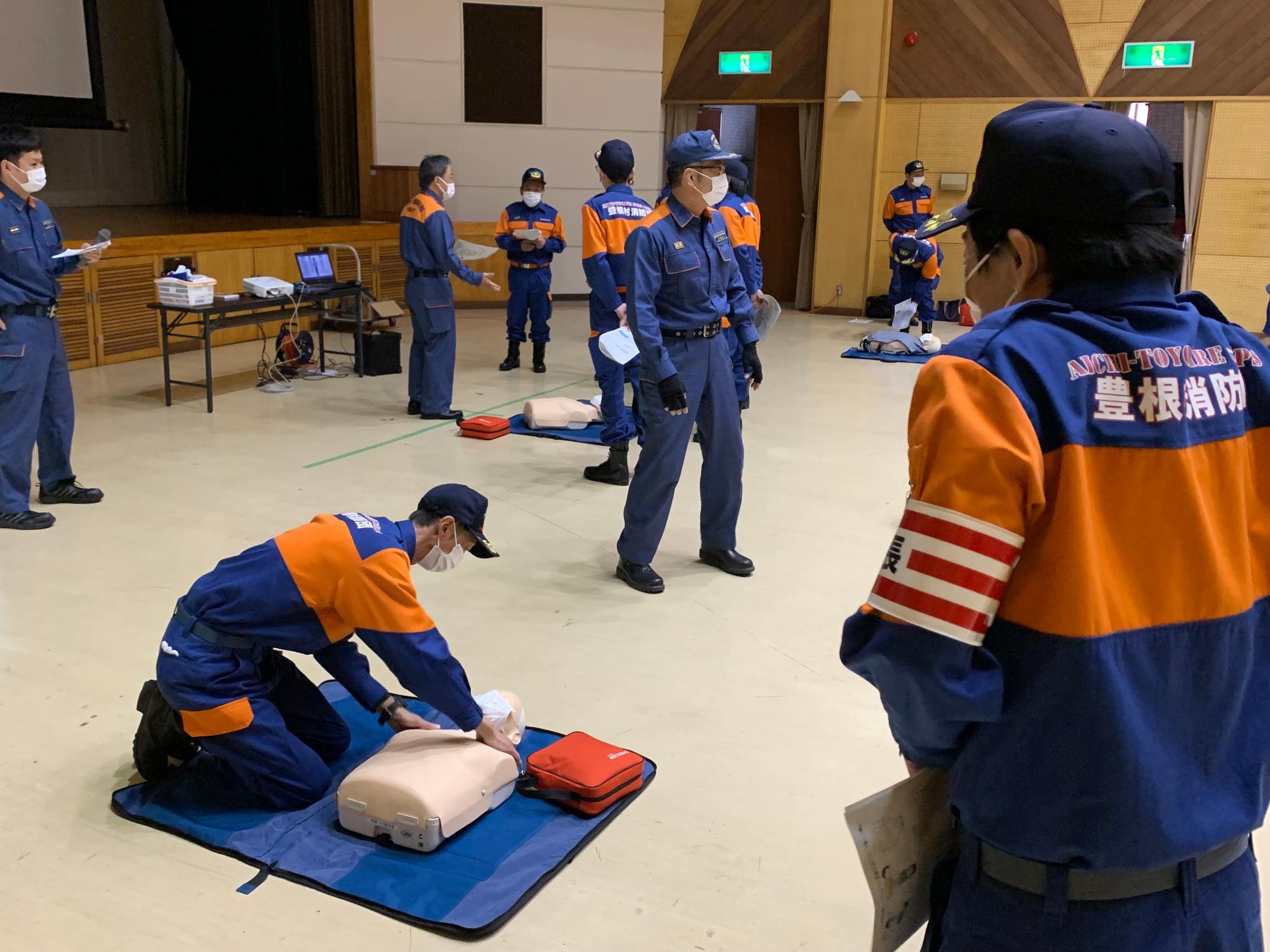 消防団員が一室に集まり、救急救命講習を行っている様子。