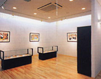 絵画や展示ケースが並んだギャラリーの写真