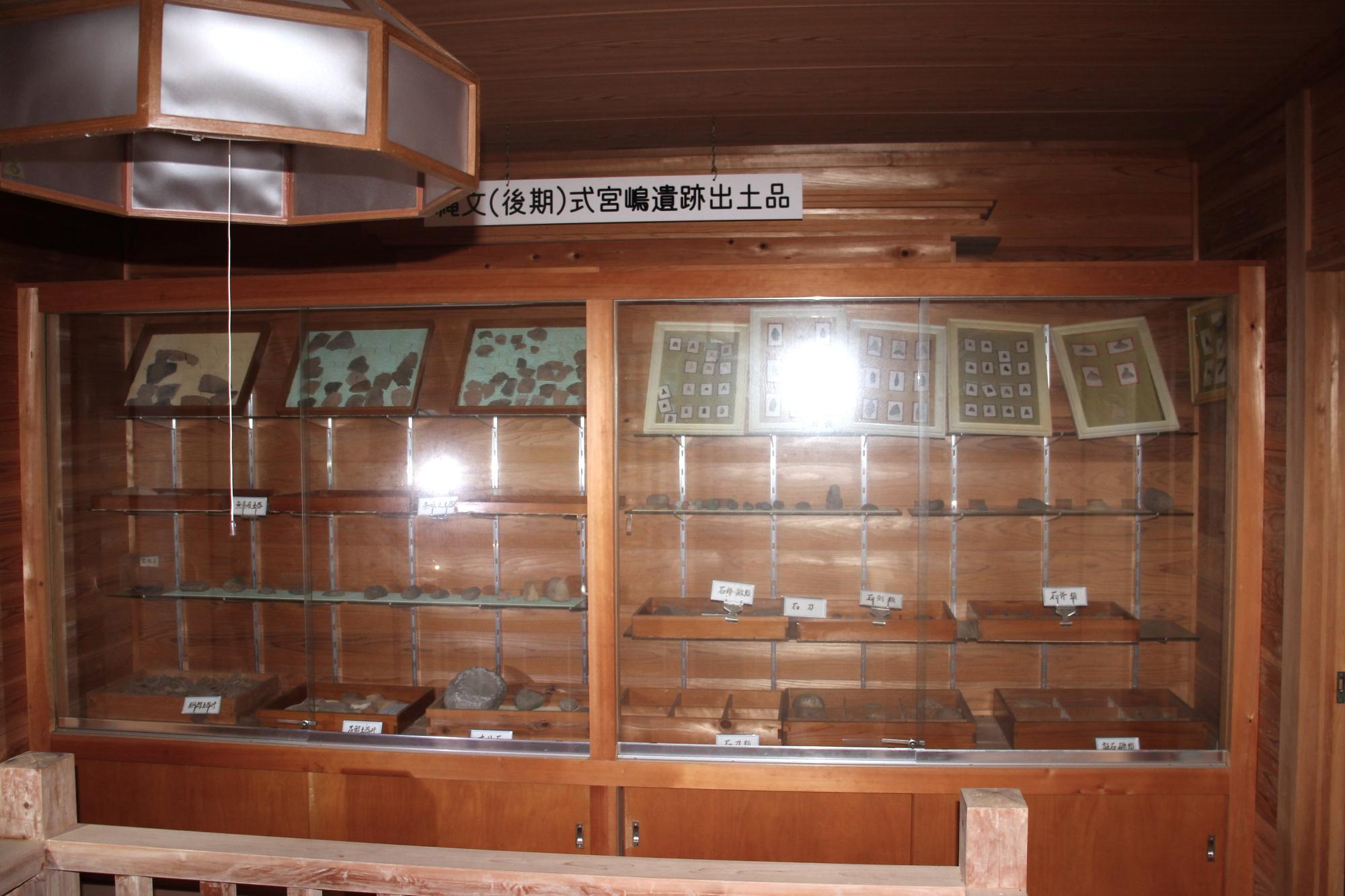 宮嶋遺跡保存館館内ショーケースに、石器が並んでいる写真